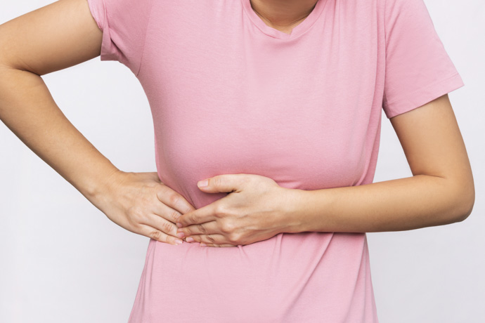 Mujer se toca costado derecho debido a dolor