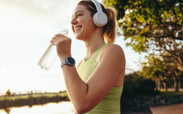 Mujer tomando agua ddurante una caminata 