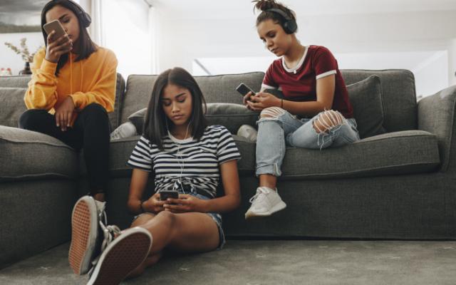 Grupo de adolescentes usando teléfono para ver memes