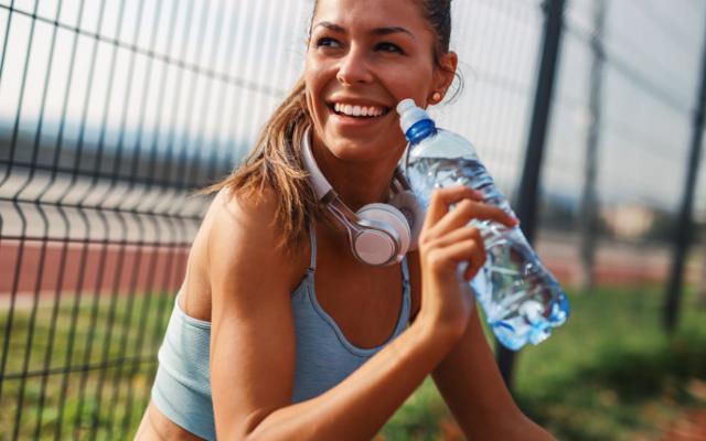 Mujer se hidrata tomando agua