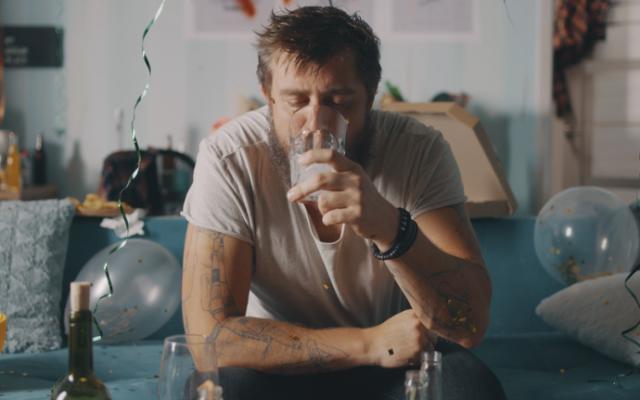 Hombre con resaca y deshidratación por alcohol