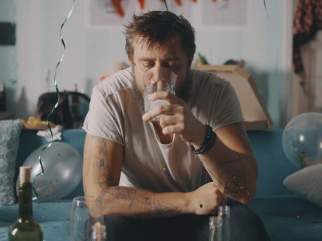 Hombre con resaca y deshidratación por alcohol