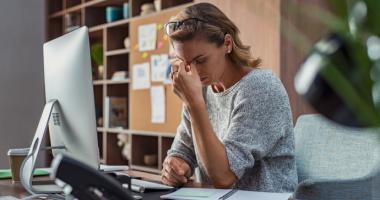 Mujer quejándose del dolor de cabeza por el burnout.