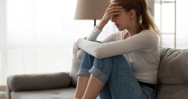 mujer sentada en el sofá con pensamientos intrusivos